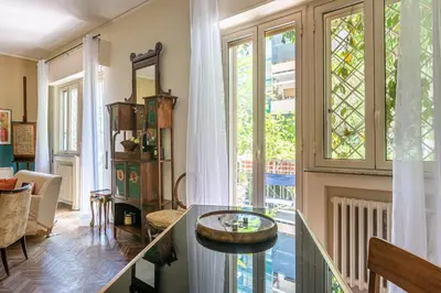 a living room with a table and a large window at Un Giardino Segreto a Palermo by Wonderful Italy in Palermo