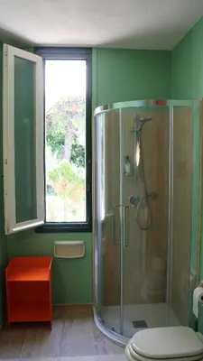 a bathroom with a shower with a toilet and a window at Modernist Villa With Private Sea Access in Bagheria