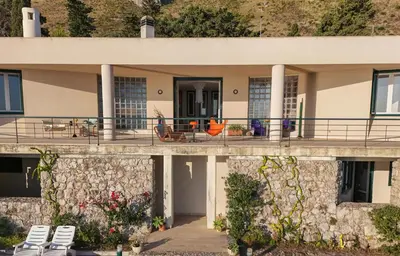 a house with a stone wall at Modernist Villa With Private Sea Access in Bagheria