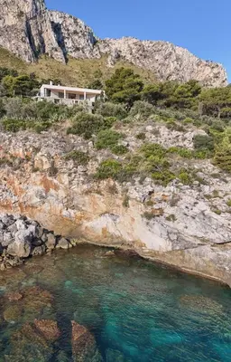 a house on the side of a mountain with a body of water at Modernist Villa With Private Sea Access in Bagheria