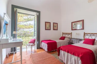 a bedroom with two beds and a balcony at Baglio del Grillo in Grisi