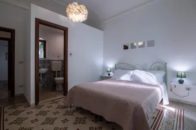 a bedroom with a bed and a chandelier at GuestHouse - 21 Steps to Everywhere in Palermo in Palermo