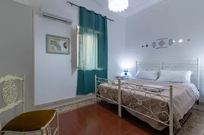 a bedroom with a bed and a green curtain at GuestHouse - 21 Steps to Everywhere in Palermo in Palermo