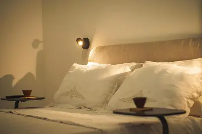 a bedroom with a bed with pillows and two tables at qanatapartment in Palermo