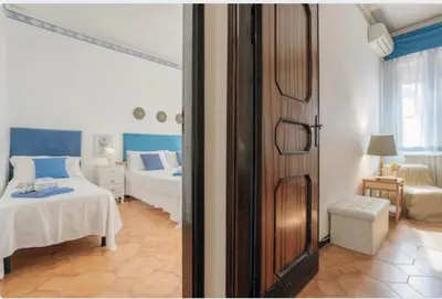 a bedroom with two beds and a room with a window at incantevole casa vacanze myu in Cinisi