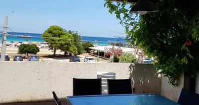 a table and chairs with a view of a beach at Villa Tra Cielo e Sabbia 2 in San Vito lo Capo