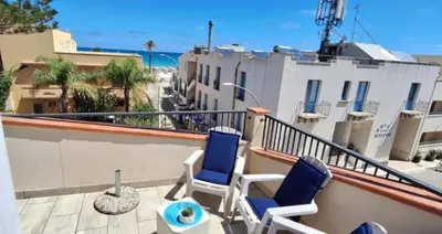 a balcony with two chairs and a view of the ocean at Casa Angolo di Mare in San Vito lo Capo