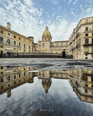 a building with a reflection in the water in front of it at SottoCapo House in Palermo