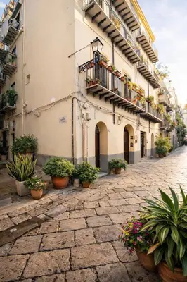 a street with potted plants on the side of a building at SottoCapo House in Palermo