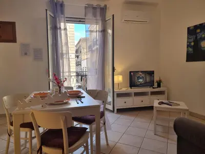 a living room with a table and chairs and a television at DownTown House by Holiday World in Palermo
