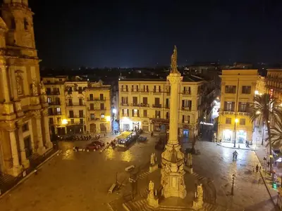 a view of a city at night with a clock tower at DownTown House by Holiday World in Palermo