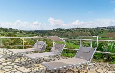 a group of chairs on a patio with a view at Villa Bruno in Castellammare del Golfo