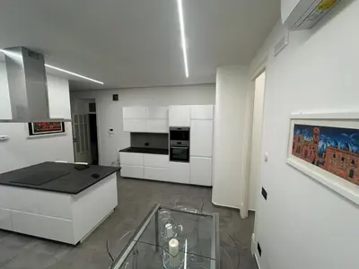 a kitchen with white cabinets and a glass table at Granatelli Apartment in Palermo