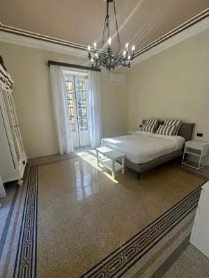 a large bedroom with a bed and a chandelier at Granatelli Apartment in Palermo