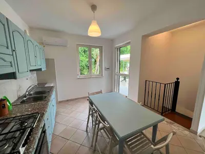 a kitchen with a table and a sink and a table at Villa Vulcano - Le Ville del Mediterraneo in Campofelice di Roccella