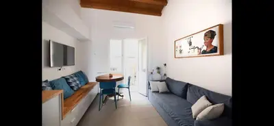 a living room with a blue couch and a table at Casa Cutó near Central Station in Palermo