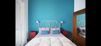 a blue bedroom with a bed with a blue wall at Casa Cutó near Central Station in Palermo