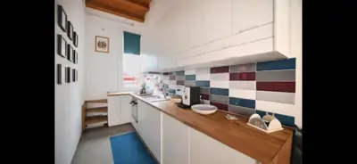 a kitchen with a counter with a sink and tiles on the wall at Casa Cutó near Central Station in Palermo