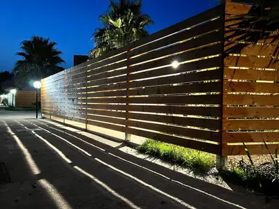 a wooden fence with lights on the side of a street at Villa Stromboli - Le Ville del Mediterraneo in Campofelice di Roccella