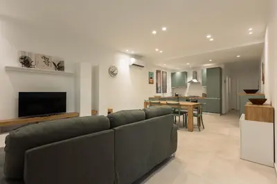 a living room with a couch and a dining room at La Dimora di Icaro - near the sea, the Airport and Palermo in Carini