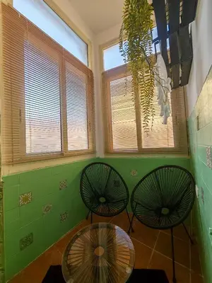 two chairs and a table in a room with windows at Guest House Scalia in Palermo