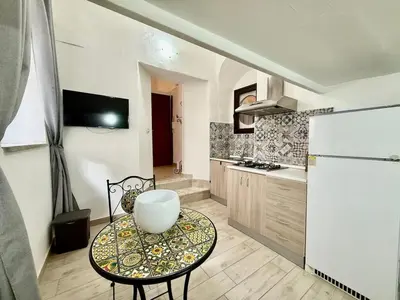 a kitchen with a table and a white refrigerator at Dimora Sant'Agostino 2 in Palermo