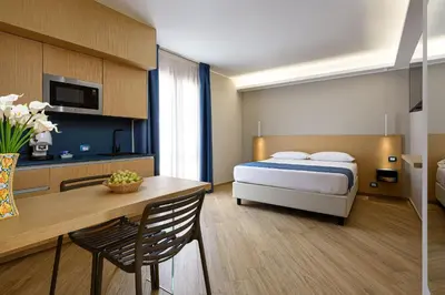 a hotel room with a bed and a desk and a table at Hotel Calliope in San Vito lo Capo