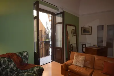 a living room with a couch and an open door at Carlita's Home in centro storico a Palermo in Palermo