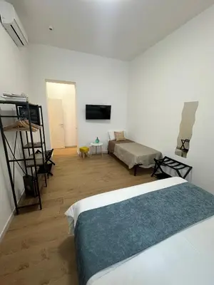 a white room with a bed and a tv at Isole Siciliane Appartamento in Palermo