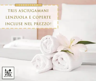 a couple of towels on a table with a flower at Pine Beach House - Villaggio Turistico con Piscina e Animazione in Campofelice di Roccella