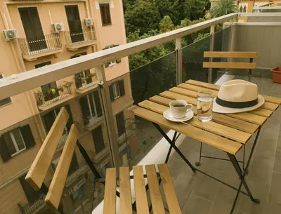 a table with a hat and a cup of coffee on a balcony at Central Apartment Cavour in Palermo