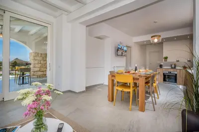 a kitchen and dining room with a table and chairs at Villa Coraline in Castellammare del Golfo