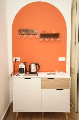 a kitchen with an orange wall and a counter at La Dimora di Guglielmo Tourist Rental in Palermo