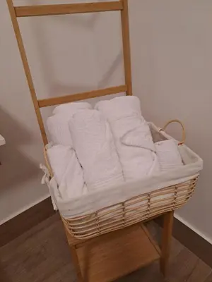 a basket filled with white towels on a shelf at La Dimora di Guglielmo Tourist Rental in Palermo