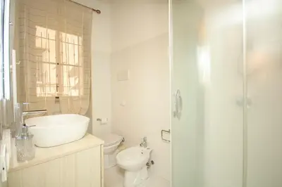 a white bathroom with a sink and a toilet at La Dimora di Guglielmo Tourist Rental in Palermo