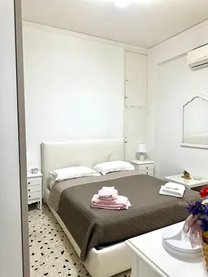 a white bedroom with a bed and a mirror at Da Nonna Marié in Palermo