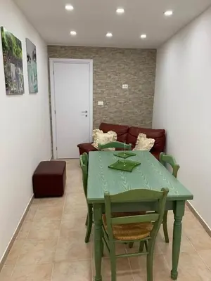 a green table and chairs in a room with a couch at Da Nonna Marié in Palermo