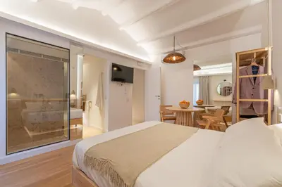 a bedroom with a large bed and a dining room at Meraki Home - Alle Spalle del Teatro Massimo in Palermo
