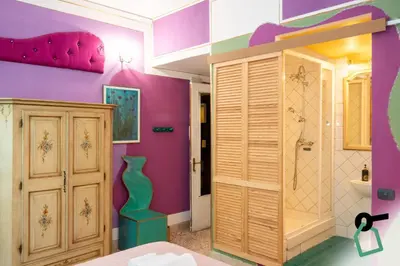 a bathroom with a pink and purple wall at Hotiday Palermo Agostino in Palermo