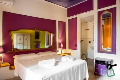 a bedroom with a white bed with a large mirror at Hotiday Palermo Agostino in Palermo