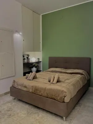 a large bed in a bedroom with green walls at Piazza Mameli Suite, comfort & elegance in Palermo in Palermo