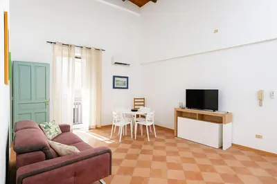 a living room with a couch and a tv and a table at Cattedrale - Vicolo Brugnò in Palermo