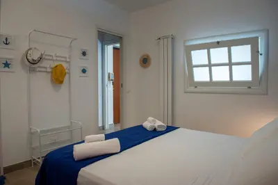 a bedroom with a large white bed with a window at CasaMare Addaura - Your Romantic Seafront Hideaway in Palermo