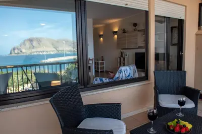 a room with a large window with a view of the ocean at CasaMare Addaura - Your Romantic Seafront Hideaway in Palermo