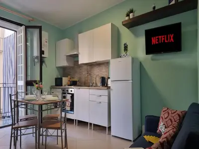 a kitchen with a table and a white refrigerator at Pruni's Home by Holiday World in Palermo