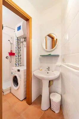 a bathroom with a sink and a washing machine at La petite Bastet in Palermo