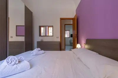 a bedroom with two white towels on a large bed at 15 min to Historic Center, 5 min to Bus, Balcony in Palermo