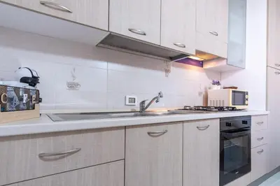 a white kitchen with a sink and a microwave at 15 min to Historic Center, 5 min to Bus, Balcony in Palermo