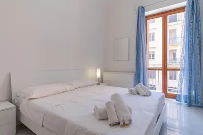 a bedroom with a white bed with towels on it at 15 min to Historic Center, 5 min to Bus, Balcony in Palermo