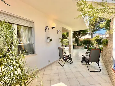 a living room with a table and a vase with flowers on it at Villa Per Sole Mare e Relax, 200 mt dalla spiaggia in Alcamo